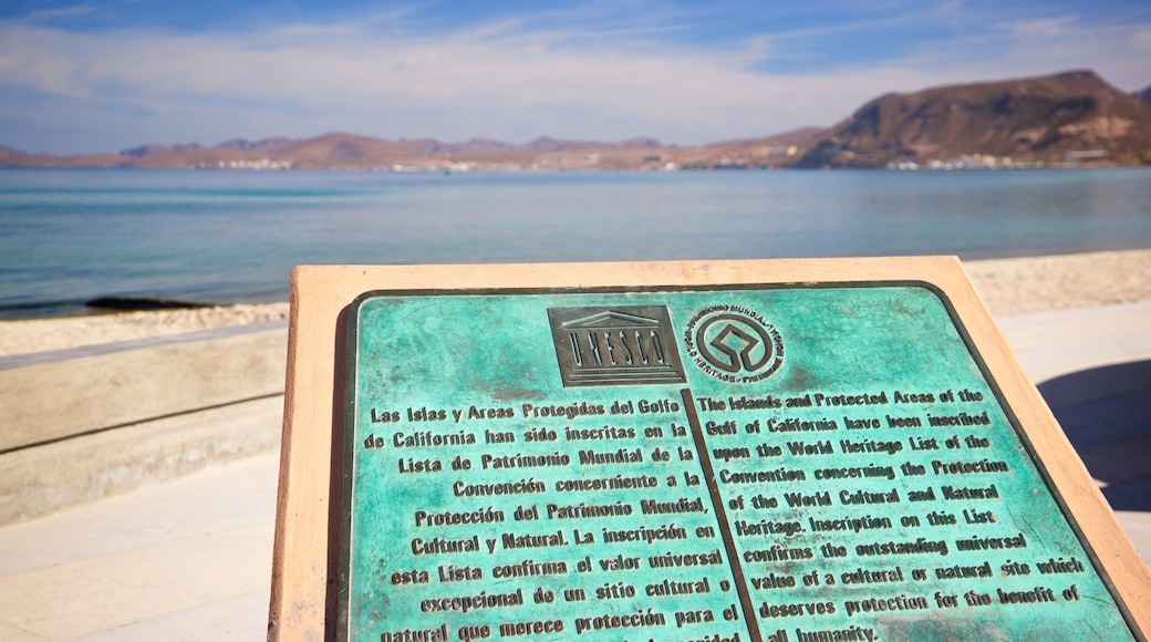 Dove of Peace Monument featuring signage and general coastal views