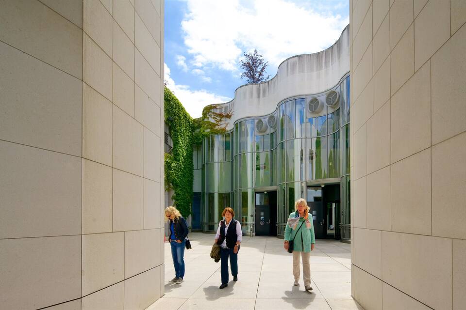 Een modern gebouw met een gebogen gevel en grote ramen.