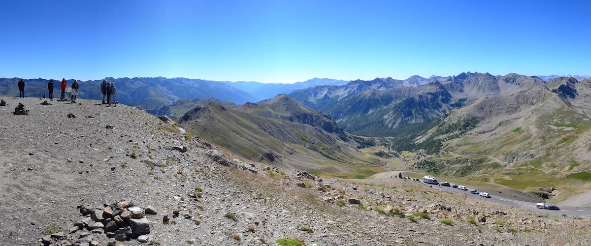 A mountainous landscape with a winding road and a stone viewing platform.