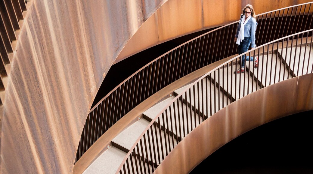 A woman on a spiral stairway, part of the modern architecture at Antinori Winery Nel Chianti Classico, San Casciano in Val di Pesa, Tuscany, Italy.