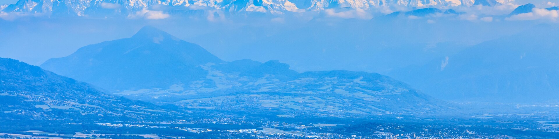 Image of snow-capped Mont Blanc Massif and Leman Lake seen from Jura Mountains in France.