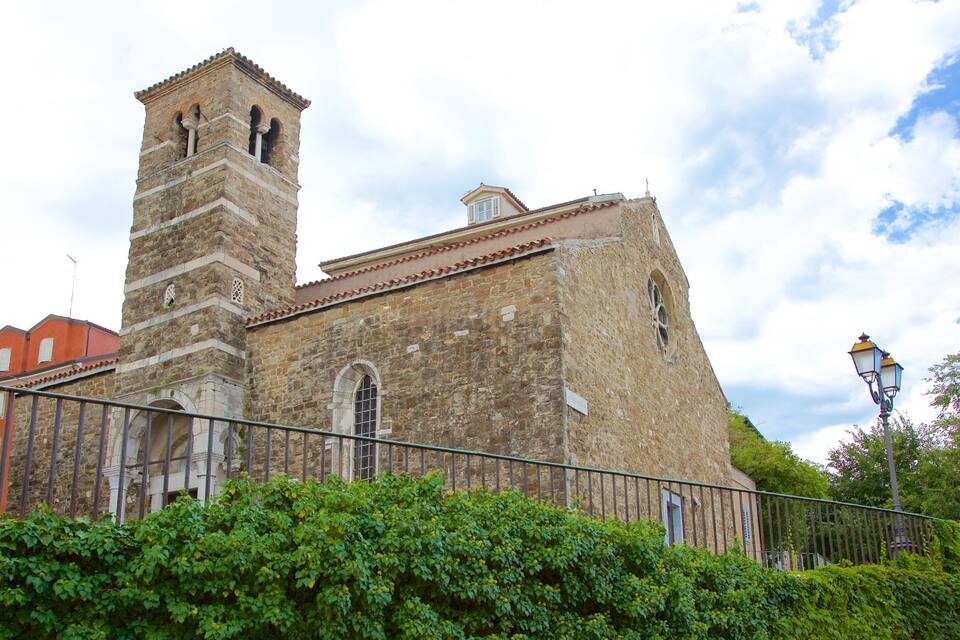 Una iglesia histórica con un campanario y tejado de tejas.