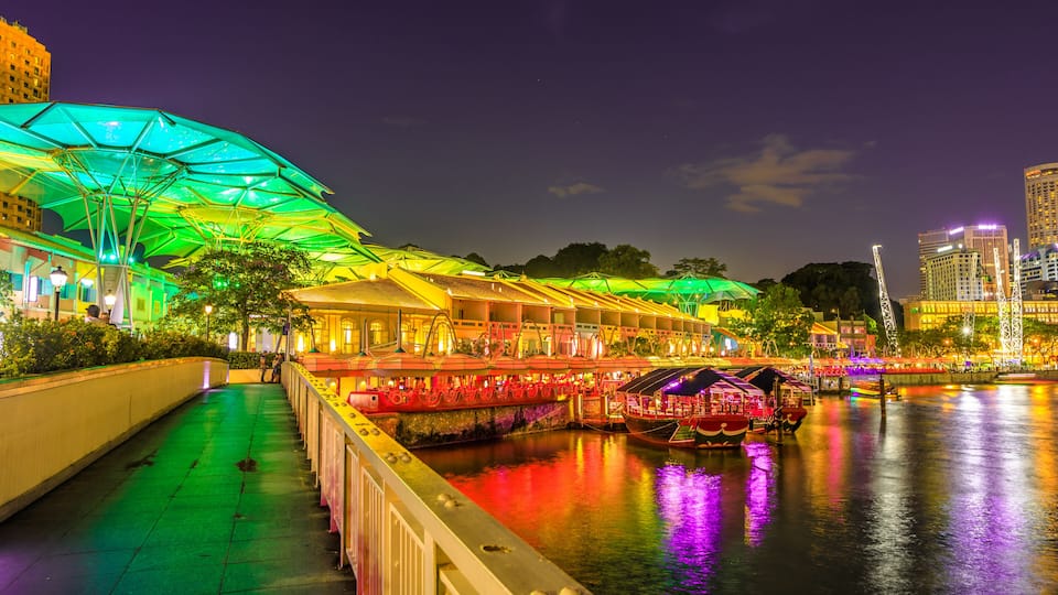 Clarke Quay bridge and Riverside area at evening in Singapore, Southeast Asia. Waterfront skyline reflected on Singapore River. Popular attraction for nightlife.