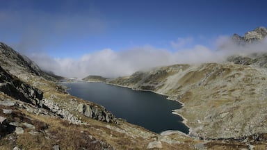 A mountainous landscape with a lake surrounded by rocky terrain and towering peaks.