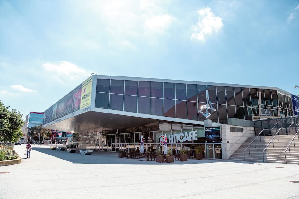 A modern building with large glass windows and a sign for 'HITCAFE'.
