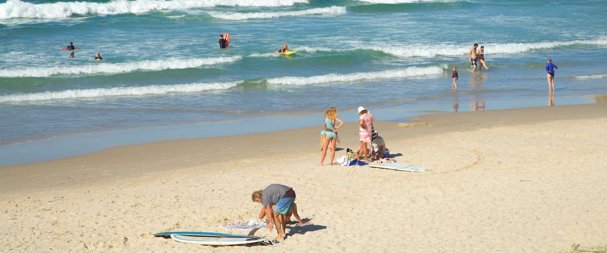 Broken Head que incluye una playa de arena y también un gran grupo de personas