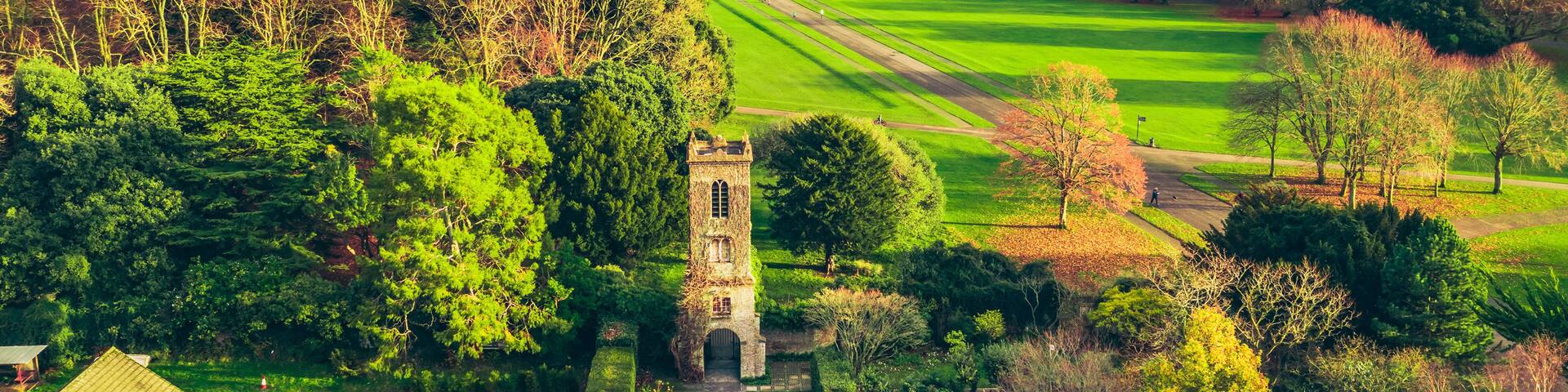 Aerial view over the St. Anne Park, revealing the old tower and the Howth peninsula on the horizon. Autumn Irish landscape in November.