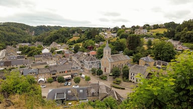 A historic town with a prominent church and a castle in the background.