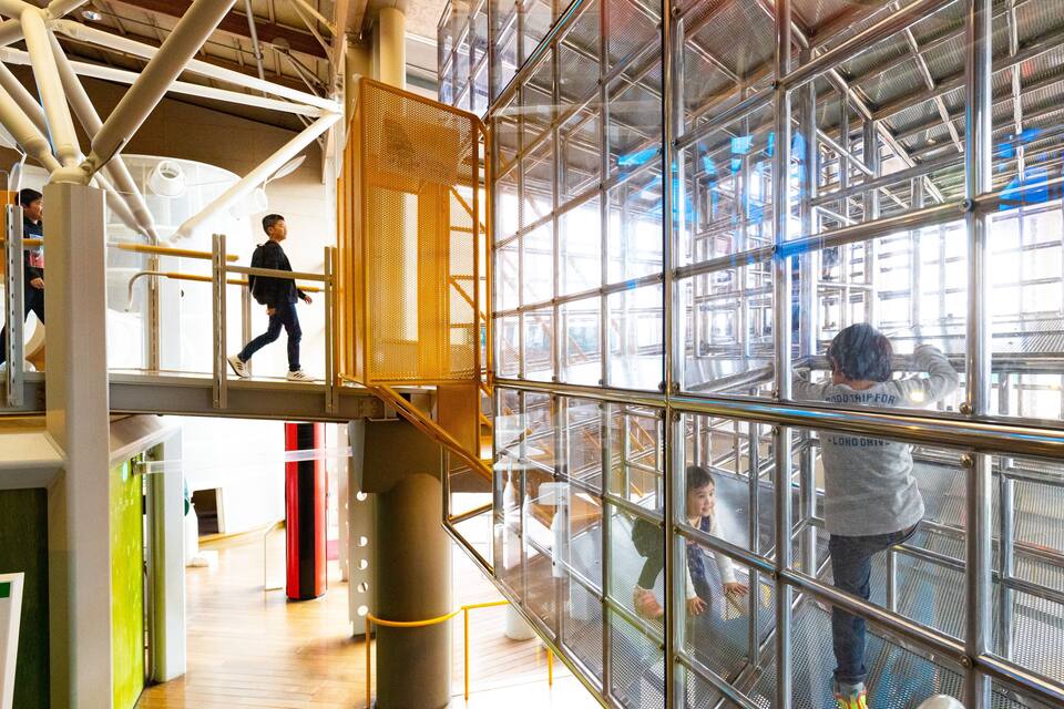 A modern industrial building with metal scaffolding and a glass facade.