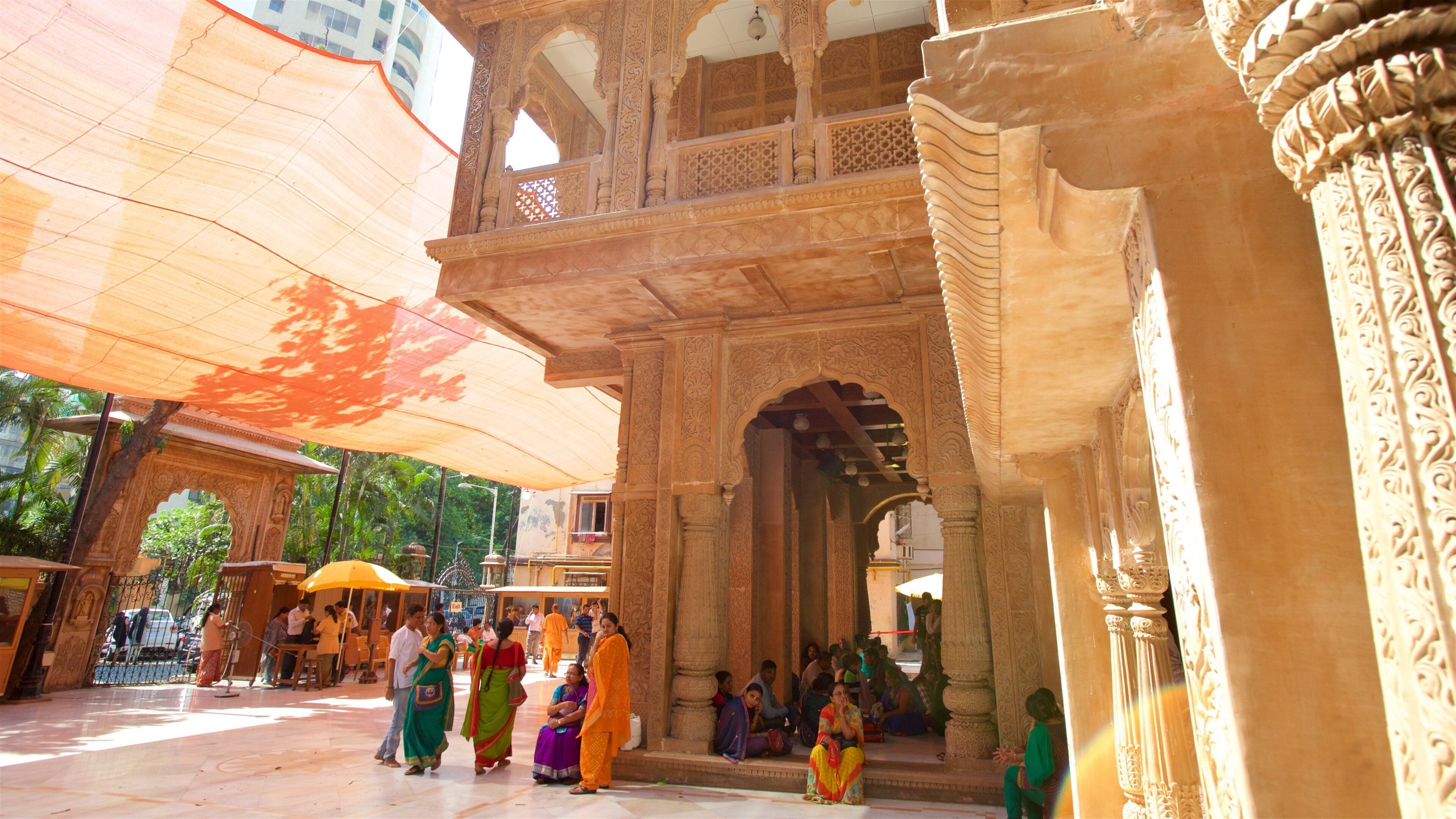 An ornate architectural structure with intricate carvings and a large canopy providing shade.