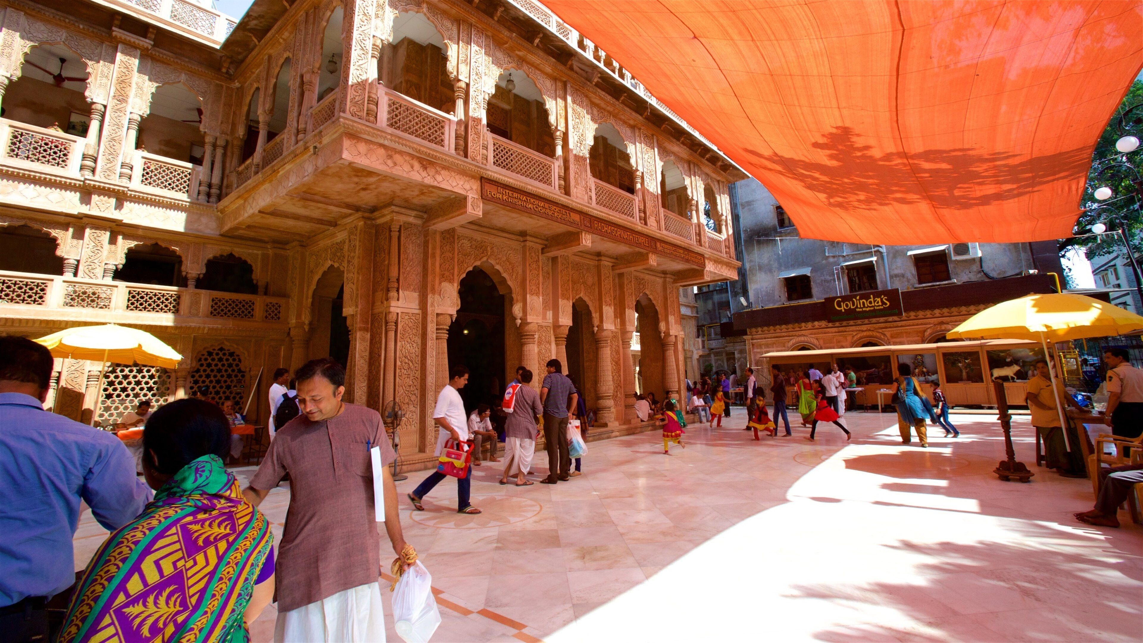 A historic building with intricate carvings and a large orange canopy.