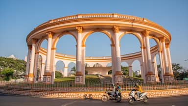 Un grand et somptueux pavillon, orné de nombreuses arcades et de colonnes, entouré d’une clôture et de verdure.