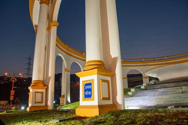 Ein großes weißes Denkmal mit goldenen Akzenten und einem blauen Schild mit Text.