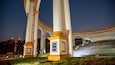 A large white monument with golden accents and a blue sign with text.