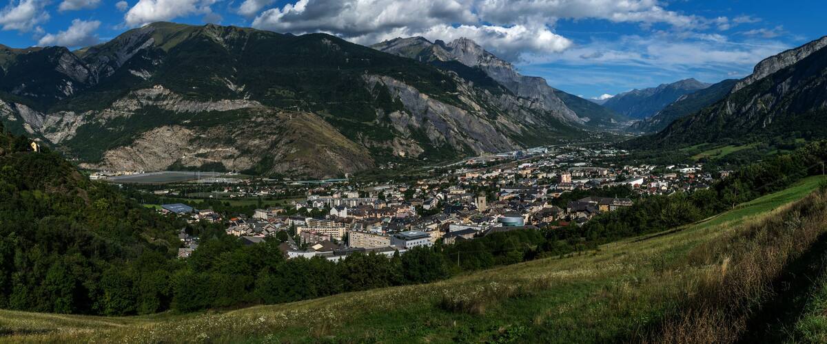 A town nestled in a valley with mountains in the background.