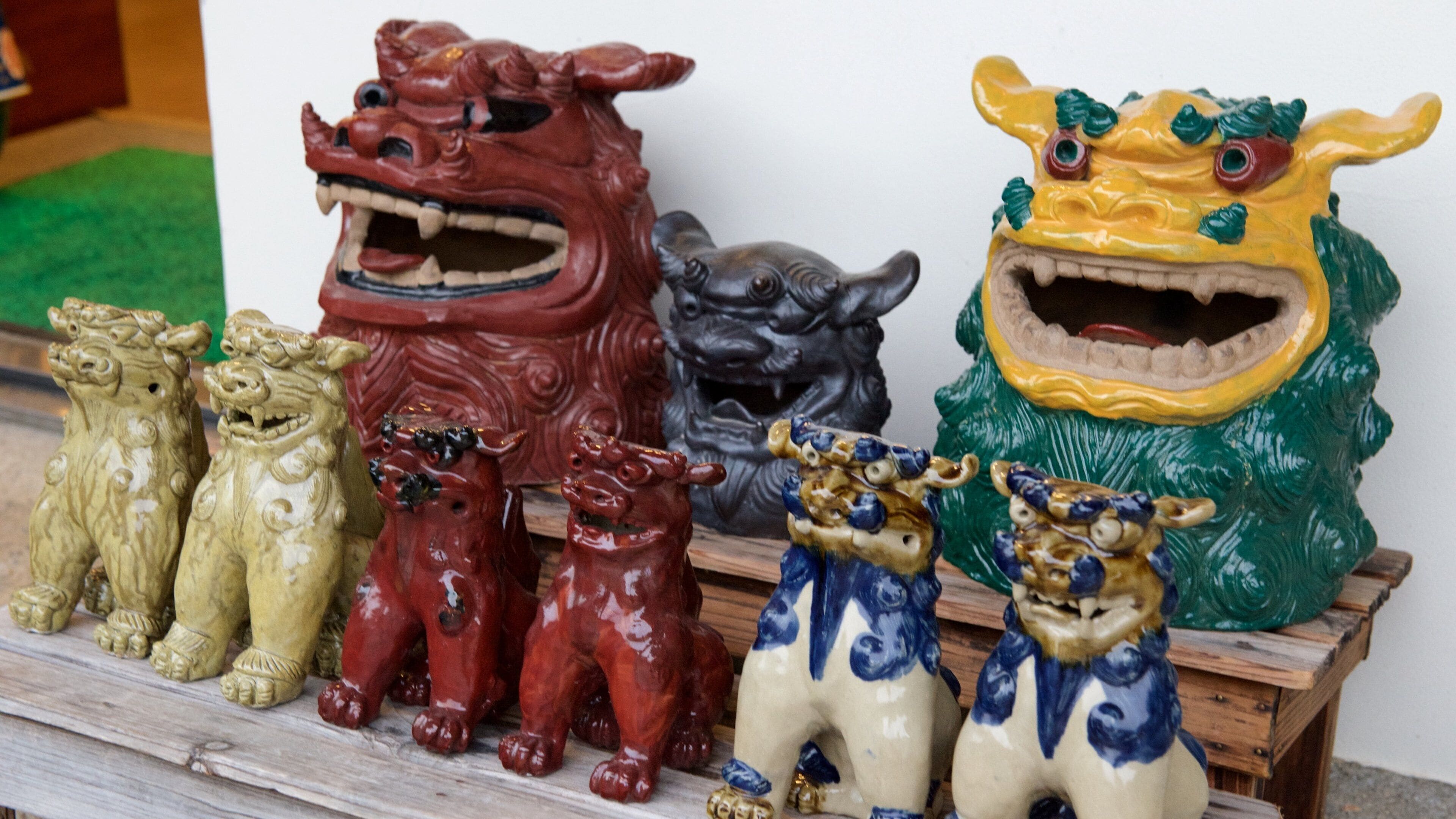 A collection of ceramic animal figures, including a red dragon, a yellow dragon, and various other animals.