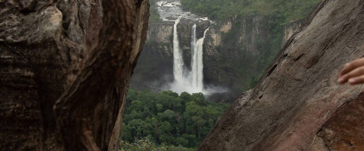 Une cascade d’eau se déversant le long d’une falaise, entourée de formations rocheuses accidentées.