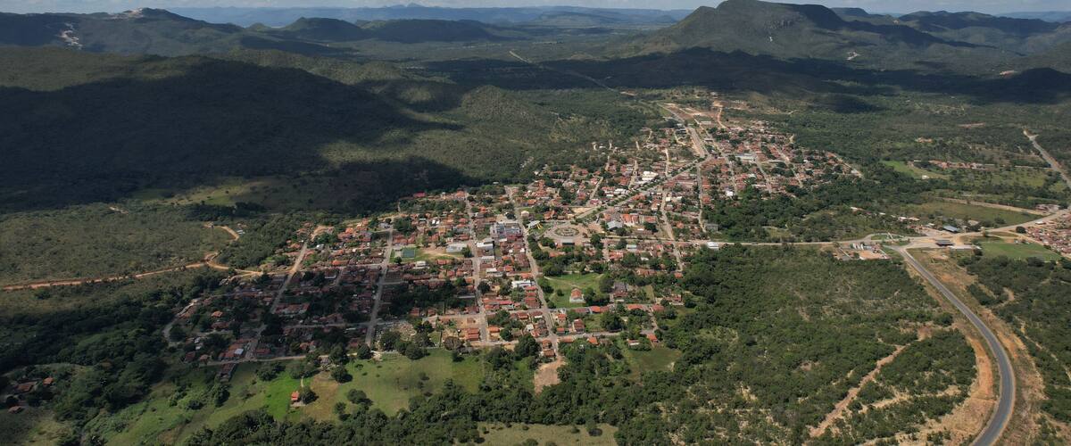 An aerial view of a town surrounded by mountains and greenery.