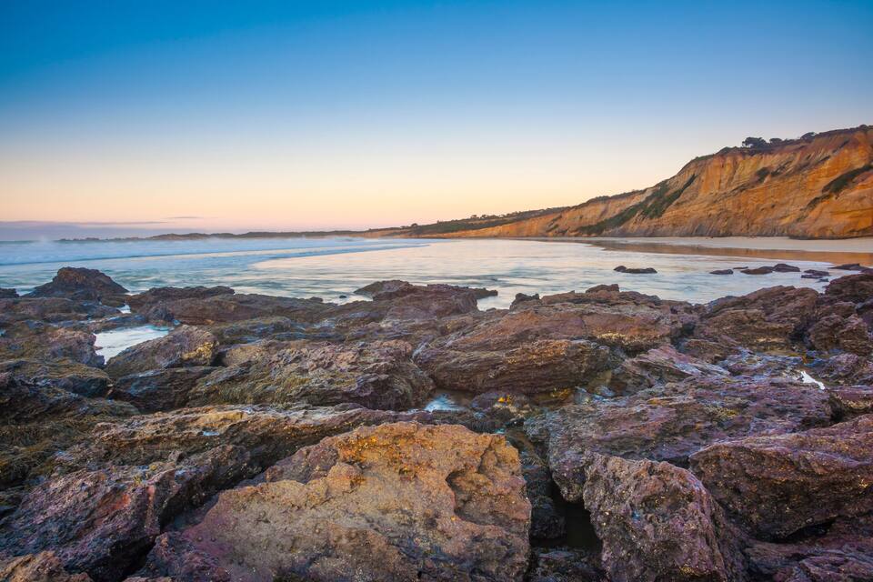 A rocky coastline with cliffs and calm sea.