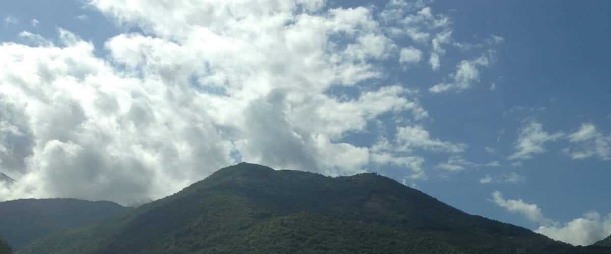 A mountain with a speed limit sign of 100 km/h.