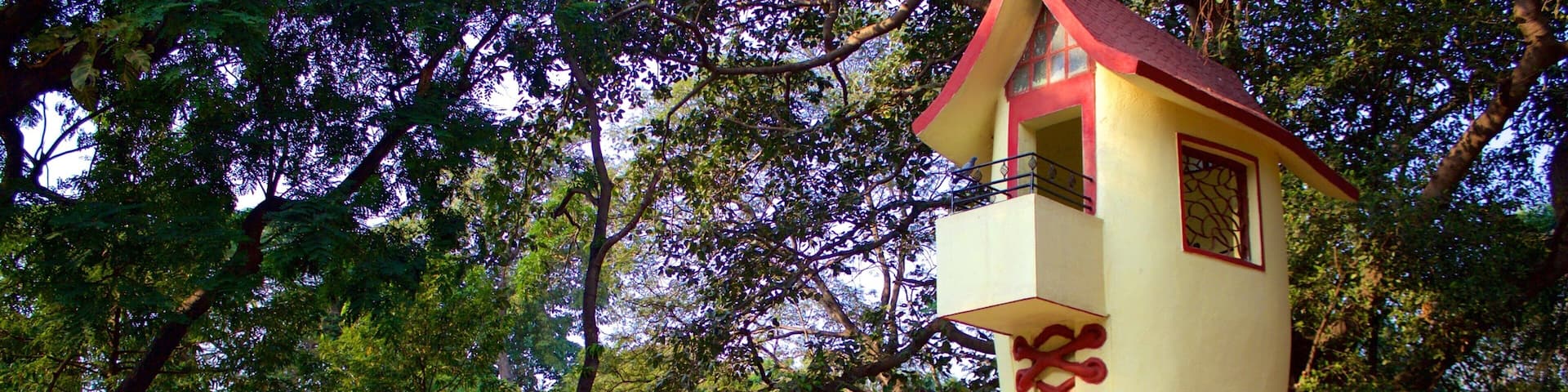 A large, uniquely shaped building resembling a giant shoe with a red and yellow color scheme, surrounded by trees.