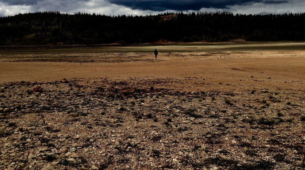 storm clouds. hiker. dry lake bed.