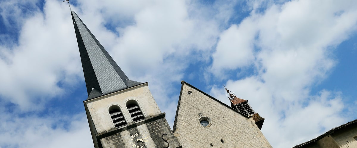 A church with a tall steeple and a clock on its tower.