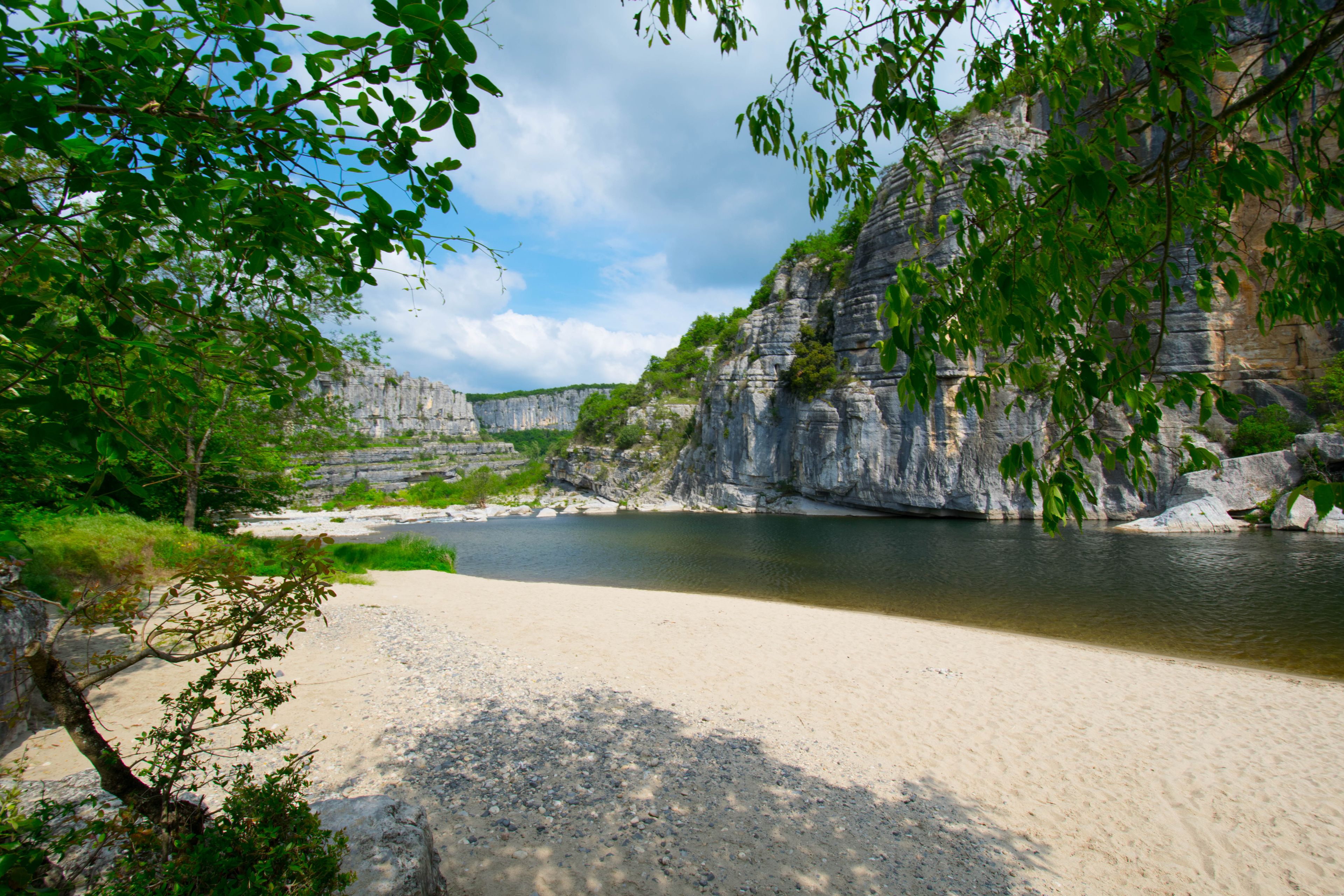Un fiume che scorre attraverso un paesaggio roccioso con scogliere e alberi.