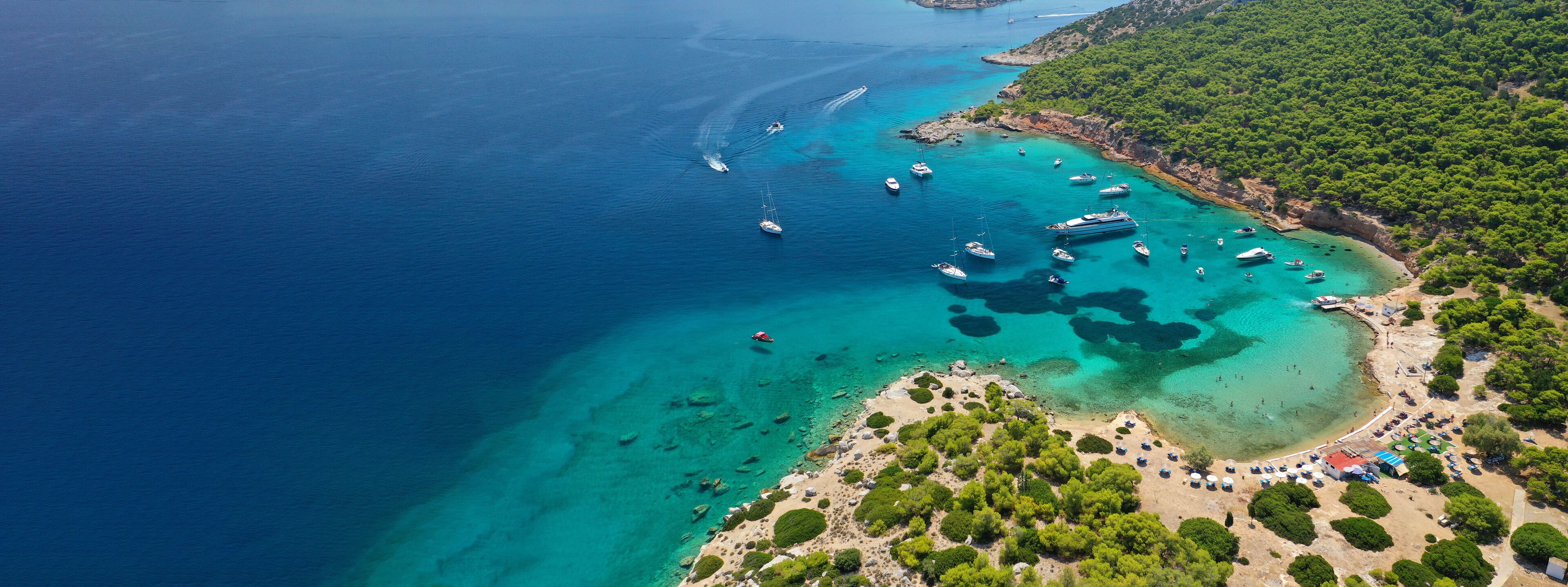 Aerial drone ultra wide photo of exotic bay of Moni island visited by yachts and sail boats, Aegina island, Saronic gulf, Greece