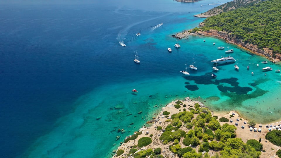Aerial drone ultra wide photo of exotic bay of Moni island visited by yachts and sail boats, Aegina island, Saronic gulf, Greece