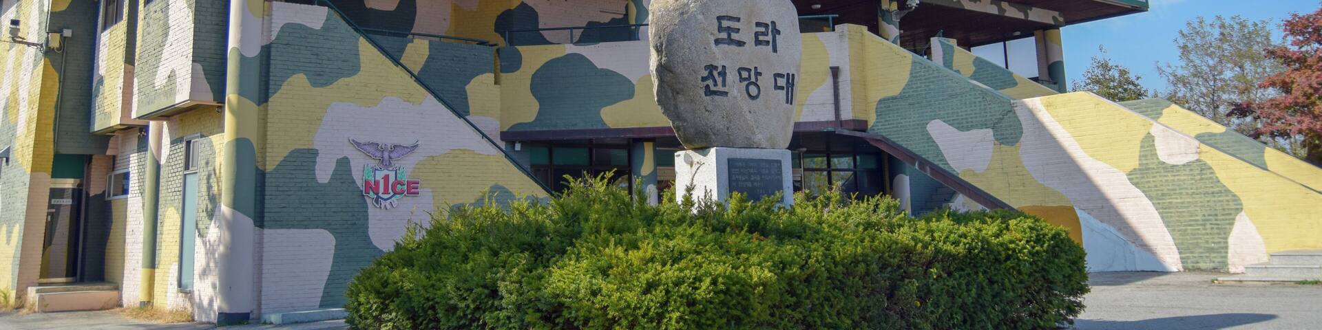 A building with a UN emblem and a sign reading "End of Separation, Beginning of Unification".