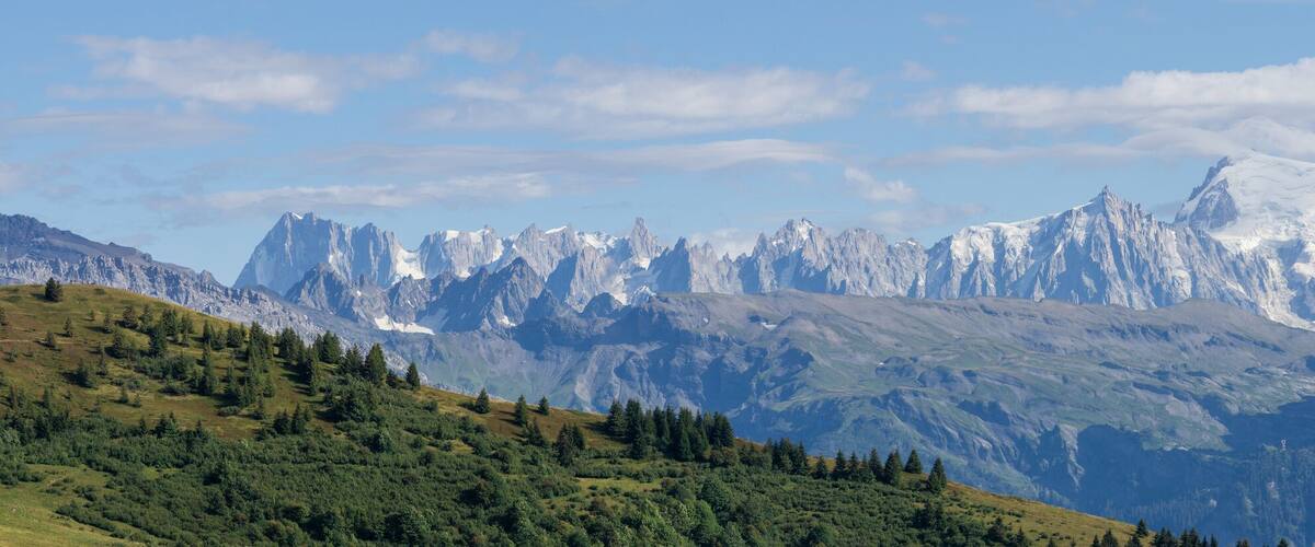 A mountain range with snow-capped peaks and lush green valleys.