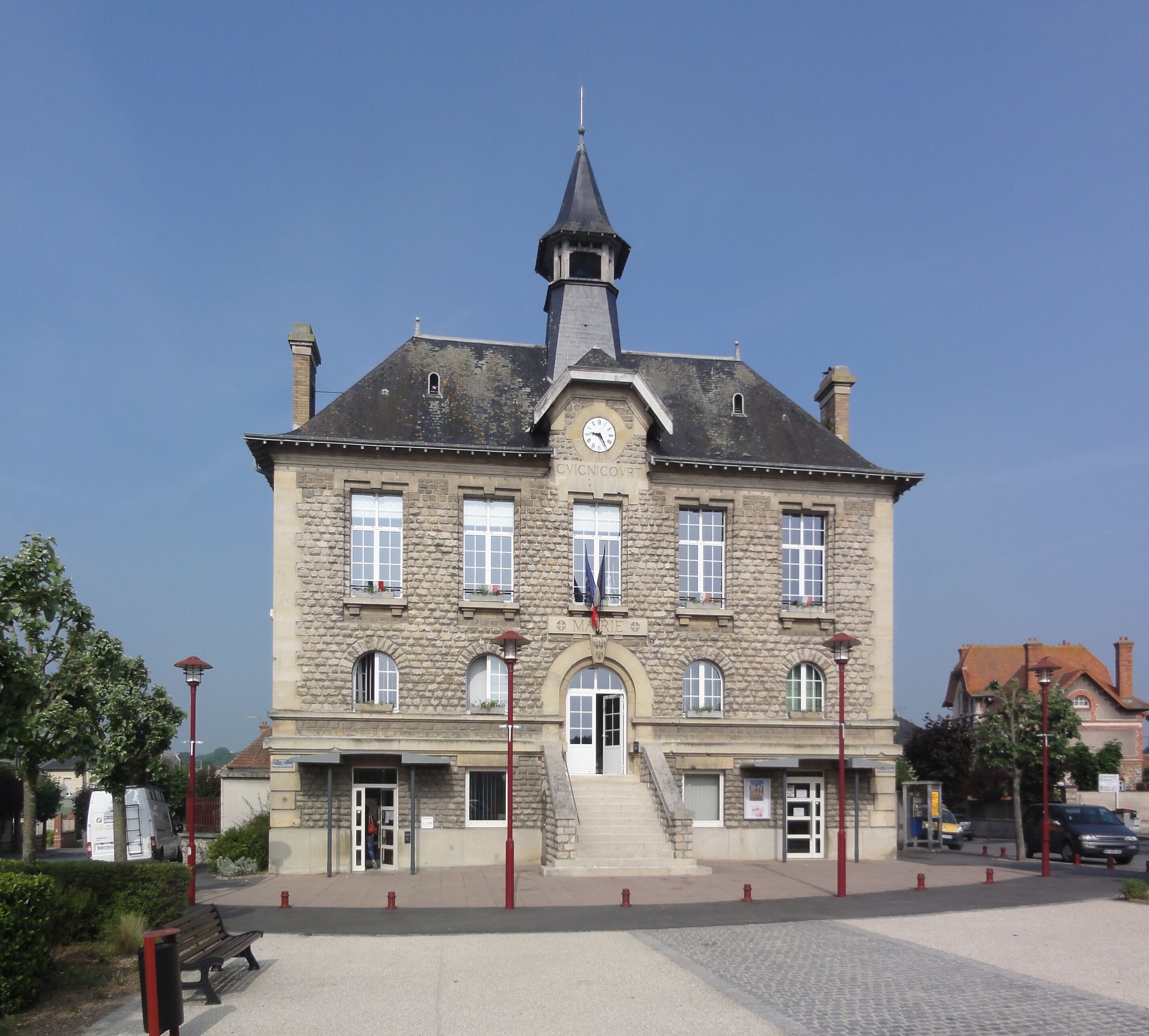 A historic stone building with a clock tower, multiple windows, and a central entrance.