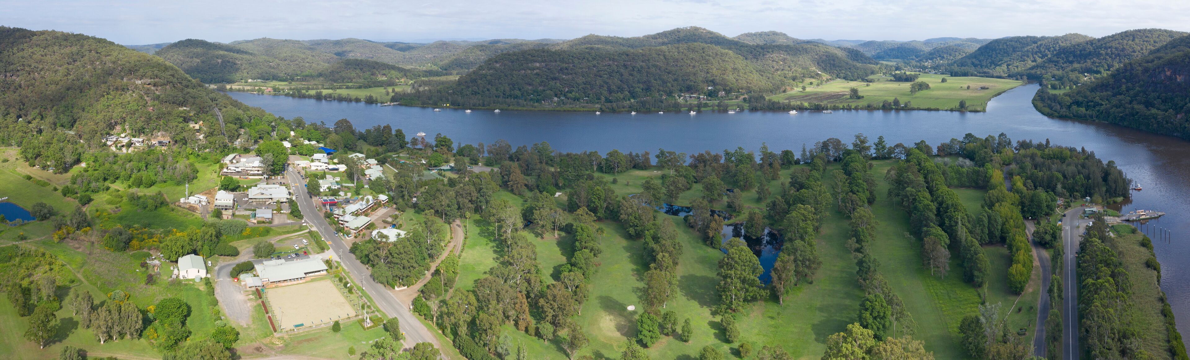 A lake surrounded by hills and a small town with buildings and roads.