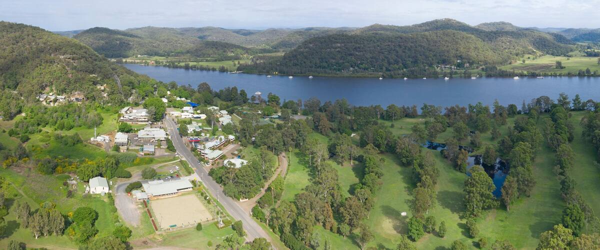A lake surrounded by hills and a small town with buildings and roads.