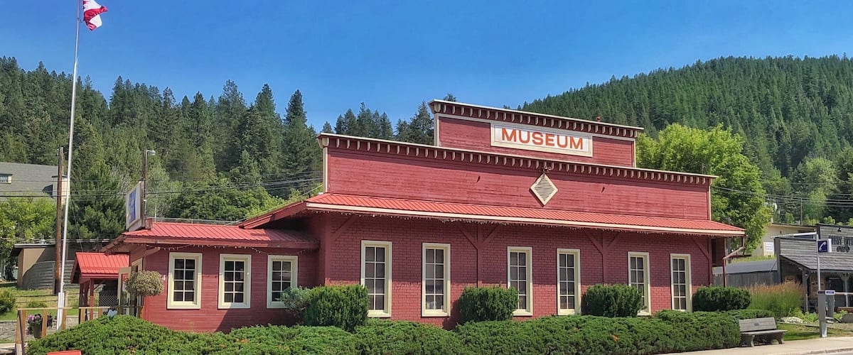 A red brick building with a sign that reads "MUSEUM" on a clear day.