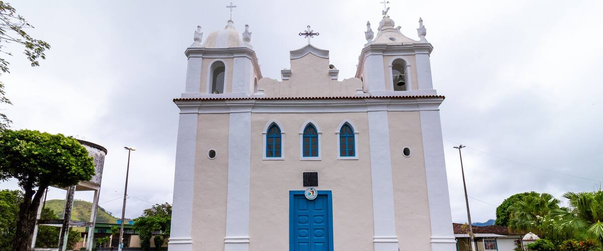 A white church with a blue door and two bell towers.