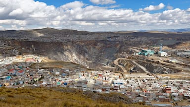 A mining town with a large open pit, buildings, and mountains in the background.