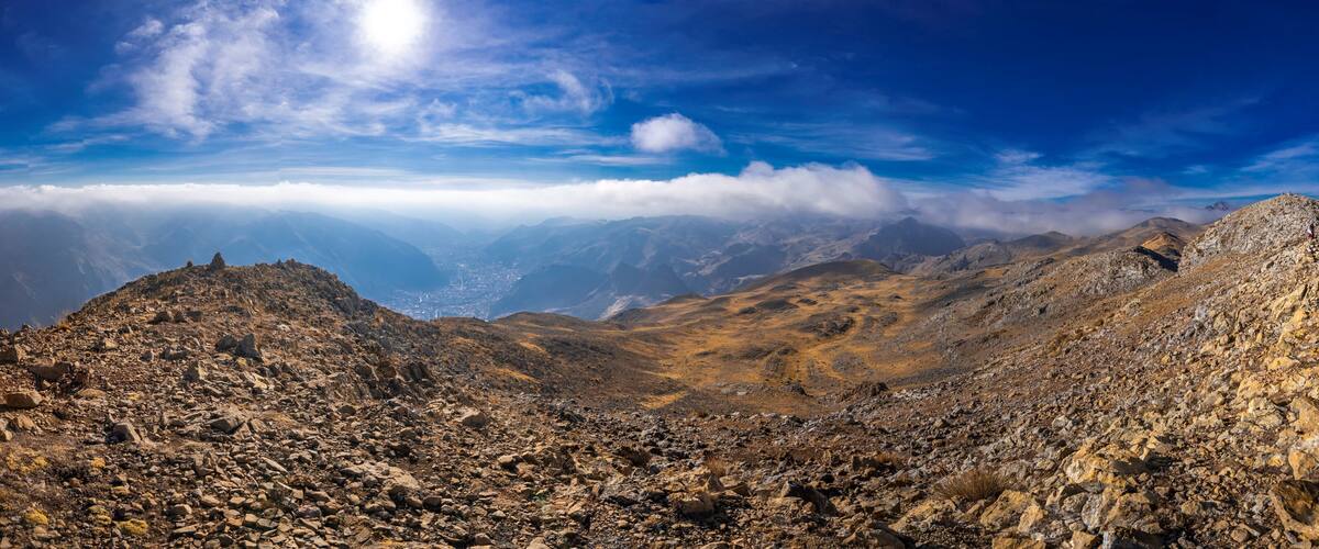 A rugged mountainous landscape with rocky terrain and a valley in the background.