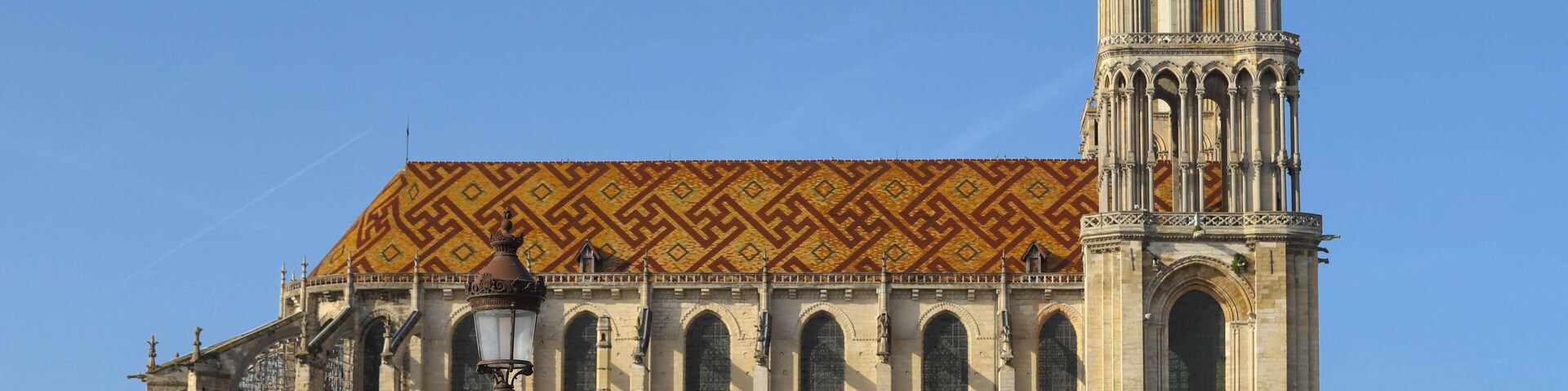 Una catedral histórica con un tejado con diseño y una alta torre de campanas.