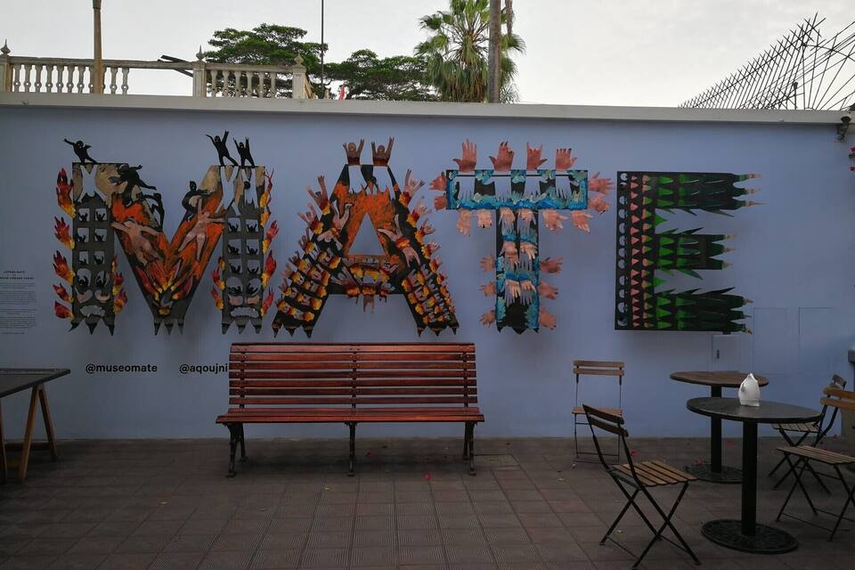 A wall art installation with the word "WATE" made of handprints.