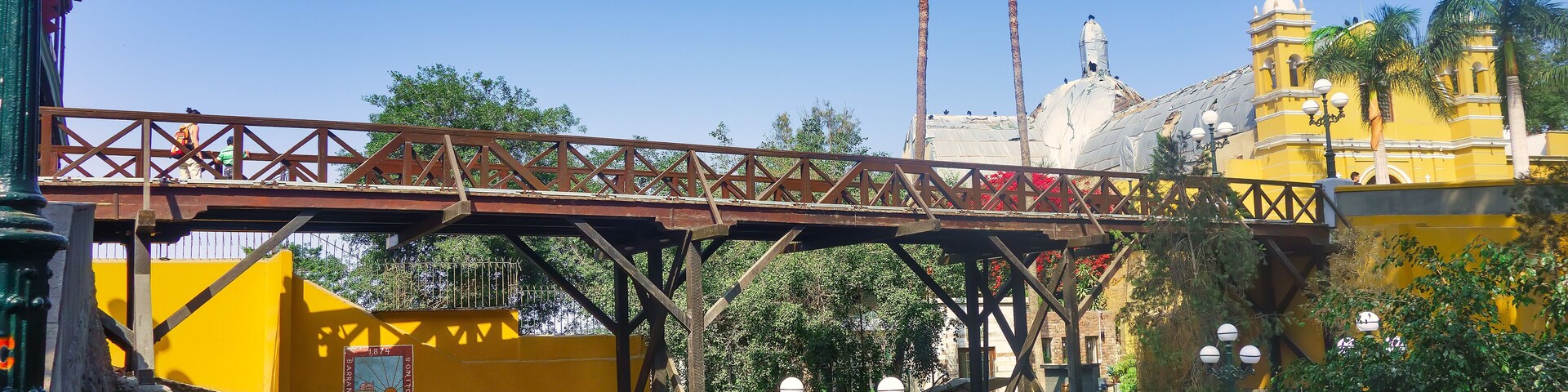 Un puente, un edificio amarillo y palmeras.