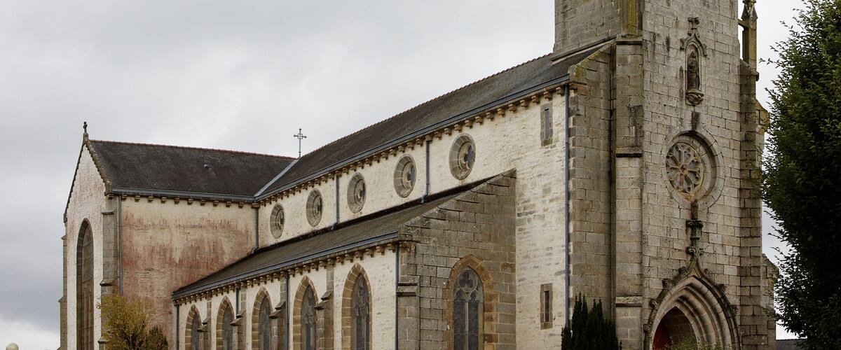 A historic church with a tall bell tower and arched windows.