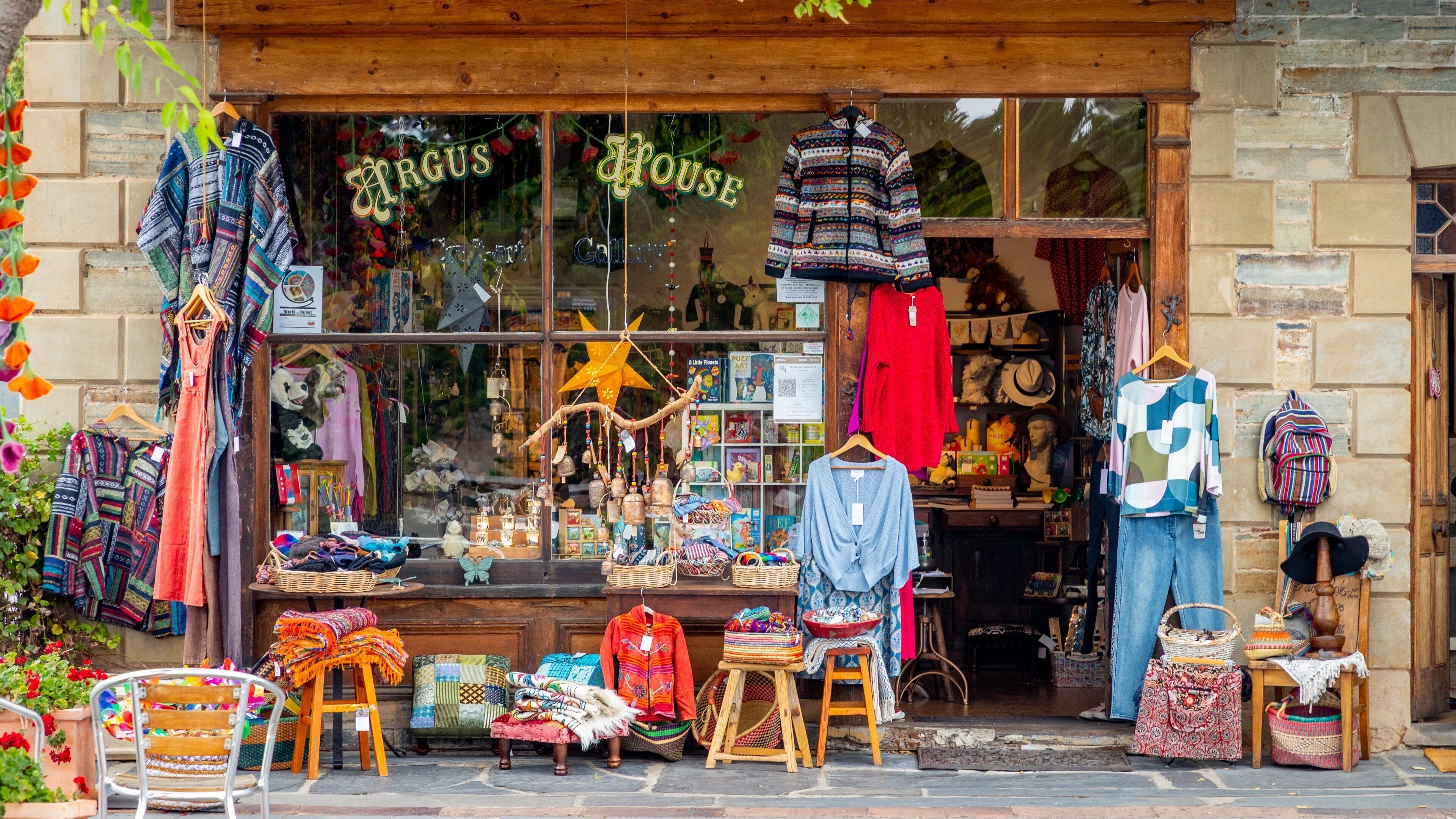 Una tienda llamada "Argus House" con textiles y artesanías de colores exhibidos en el exterior.