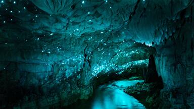 Una cueva con estalactitas y un arroyo.
