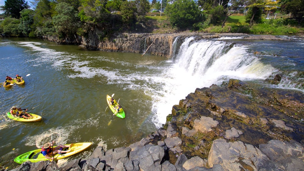 Une rivière avec une cascade, des kayaks et des berges rocheuses.
