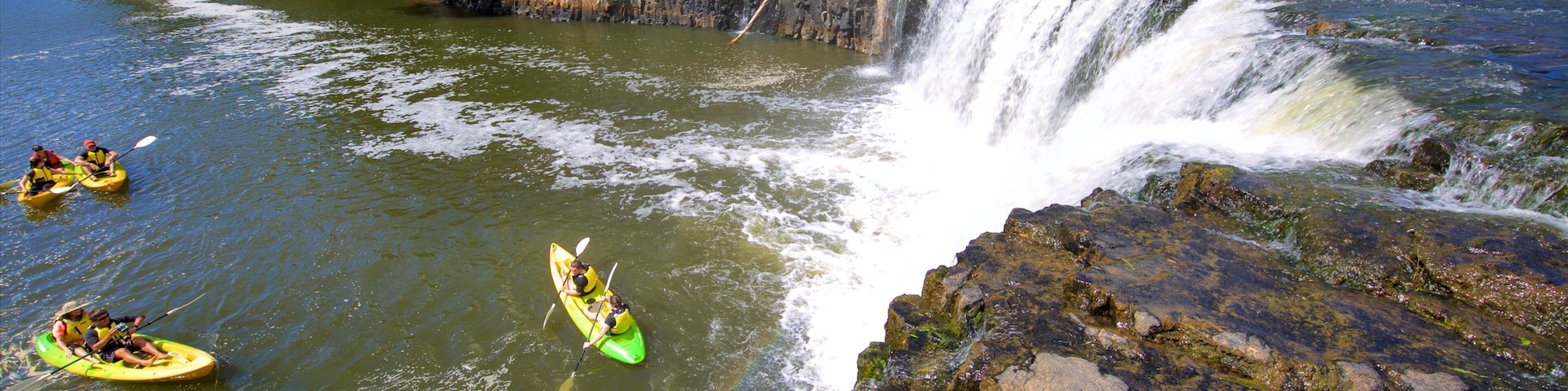 Haruru Falls showing kayaking or canoeing, a river or creek and a cascade