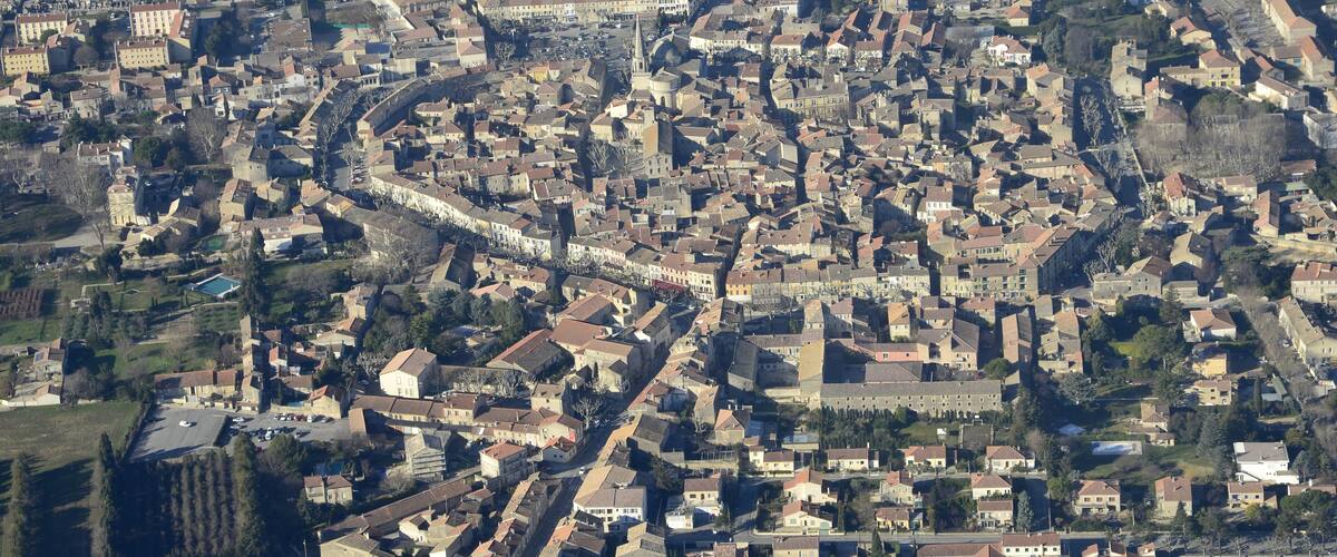 An aerial view of a densely packed town with narrow streets and historic buildings.