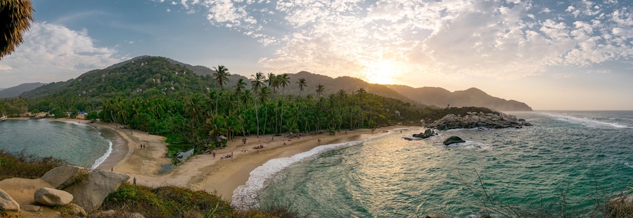 Beautiful Caribbean beach with palm trees and sunset in Tayrona National Park close to Santa Marta in Northern Colombia