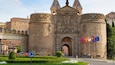 Un bâtiment historique en pierre, doté de deux grandes tours et d’une entrée centrale.